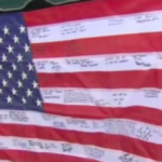 He Discovered This $5 Flag During A Garage Sale. When He Squints To Read The Writing, His Heart Drops