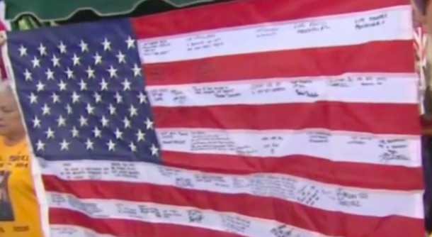 He Discovered This $5 Flag During A Garage Sale. When He Squints To Read The Writing, His Heart Drops