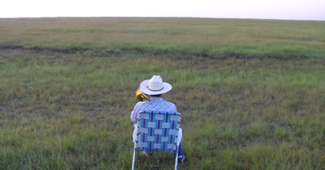 (VIDEO)A Farmer Takes a Seat in an Empty Field and Starts Playing Trombone, But Look Who Comes Running To Enjoy His Music